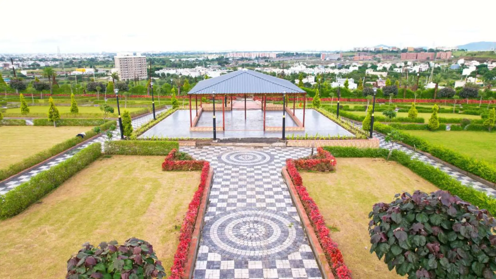 Open community pavilion set within landscaped lawns and patterned walkways